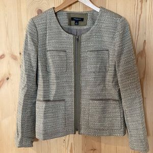 A tweed jacket with hints of green, beige and white.